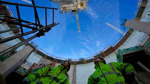 Employees look up at the construction site of Hinkley Point C nuclear power station in Somerset, England