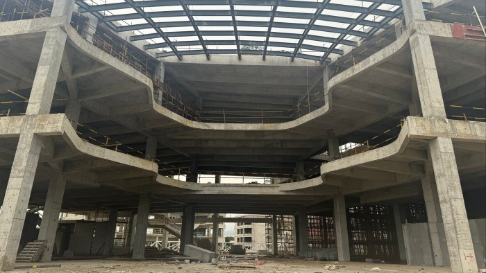 A concrete building under construction with visible floors and supporting beams