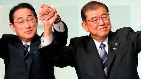 Shigeru Ishiba and Fumio Kishida hold up their hands in a gesture of victory after Ishiba is elected as the new head of Japan's ruling Liberal Democratic party