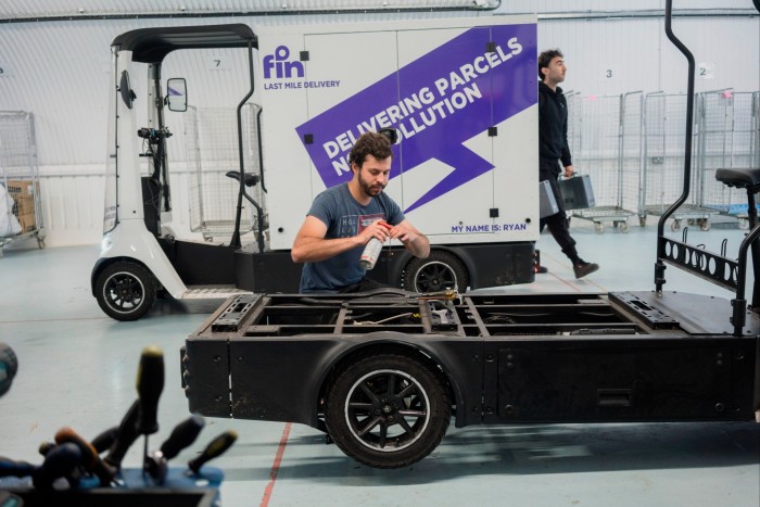 Fin Sustainable Logistics staff checking the engine underneath an e-cargo bike at a workshop in Bethnal Green, London, England on August 27 2024