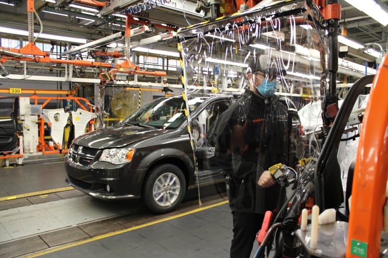 An employee working on the assembly line with added safety precautions at FCA's Windsor Assembly Plant.