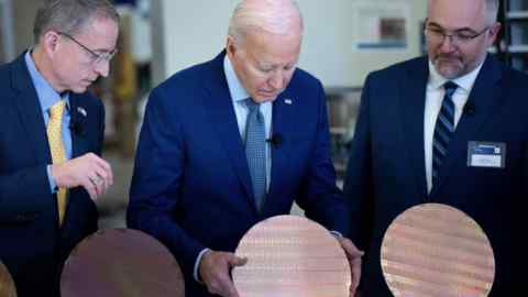 President Joe Biden inspects a semiconductor wafer at Intel’s campus in Chandler, Arizona