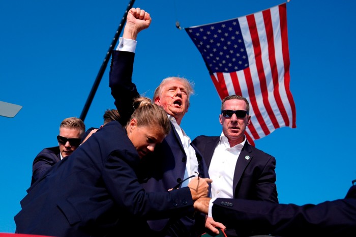 Republican presidential candidate former President Donald Trump is surrounded by U.S. Secret Service agents after he was shot at a campaign rally