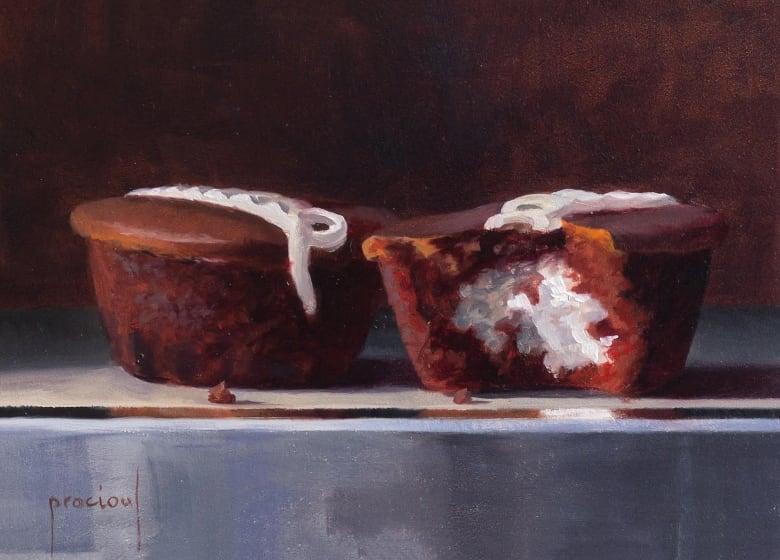 An old-fashioned looking oil painting of two round, bite-sizes chocolate cakes, each with a swirling line of white icing on the top. One has a bite taken out of it, revealing a creamy white filling.