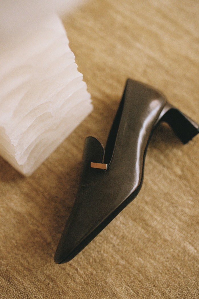 A single brown leather woman’s shoe sits on a tabletop