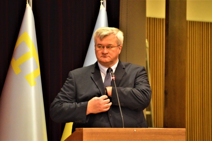 Andriy Sybiha delivers a speech in front of a podium.