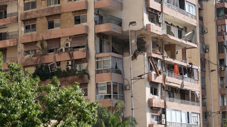 Damage can be seen where a missile struck an apartment building in the predominantly Sunni neighbourhood of Kola in central Beirut Monday,