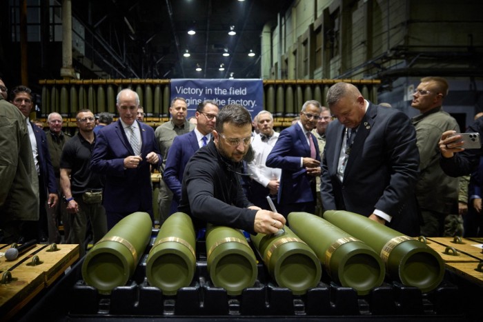 Zelenskyy signs a shell during a tour of an ammunition plant in Scranton, Pennsylvania