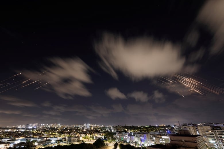 Missiles are seen over a night sky