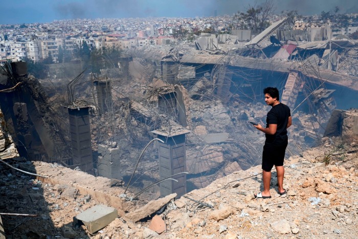 A man checks a damaged building at the site of an Israeli airstrike in Choueifat, south east of Beirut,