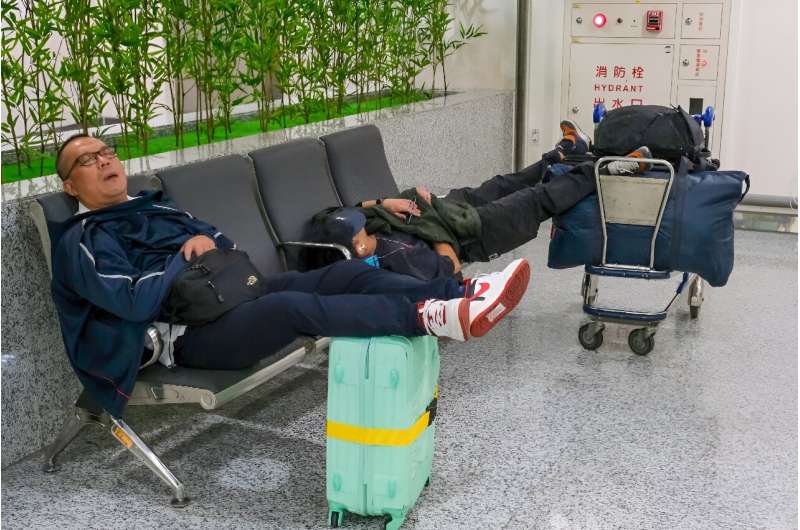 Passengers sleep at the Taoyuan international airport after all domestic flights were cancelled due to Typhoon Krathon