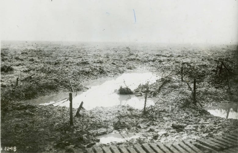 Black and white photo of a muddy and wet battlefield.