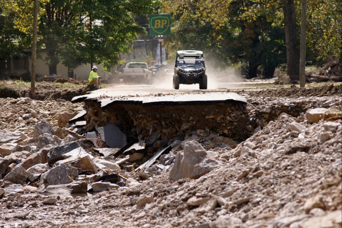 An all terrain vehicle approaches a section of destroyed road in the aftermath of Hurricane Helene, in Barnardsville, North Carolina