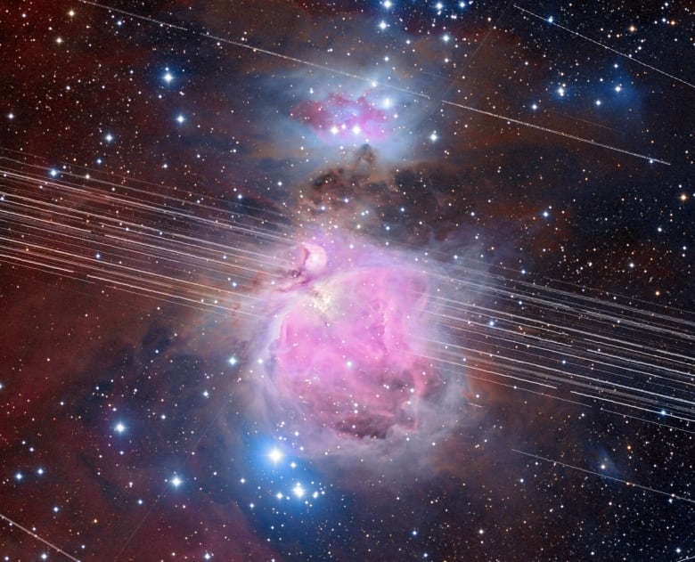 Pink clouds of gases in space with several lines streaking across the image.