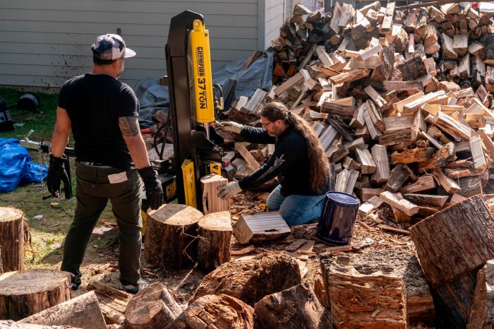 Union members cut wood, which will be burned for warmth at picketing locations, at a temporary union hall as Boeing workers picket outside of the Boeing Everett factory during an ongoing strike in Everett, Washington 