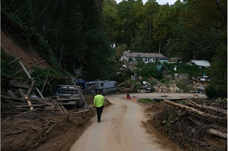 A person walks past wreckage and debris left by Hurricane Helene when it roared through North Carolina on October 3, 2024