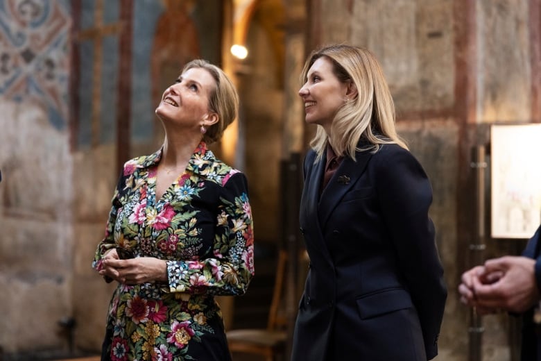 Two people in a cathedral look up at the ceiling.