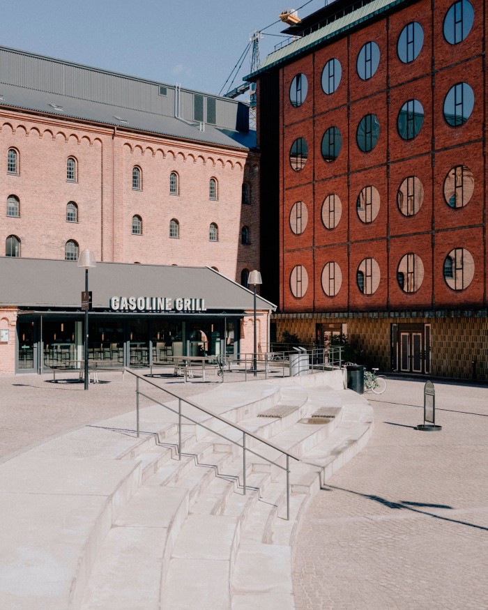 The Carlsberg Byen branch of gourmet burger restaurant Gasoline Grill, housed in a former boiler building. A red building with large porthole windows is perpendicular to its right