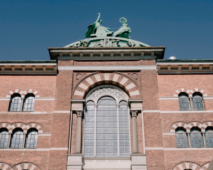 Detail of the Italian-palazzo-inspired, rose-brick New Carlsberg Brewhouse, with a blue copper sculpture of a mythological figure riding a chariot on its roof