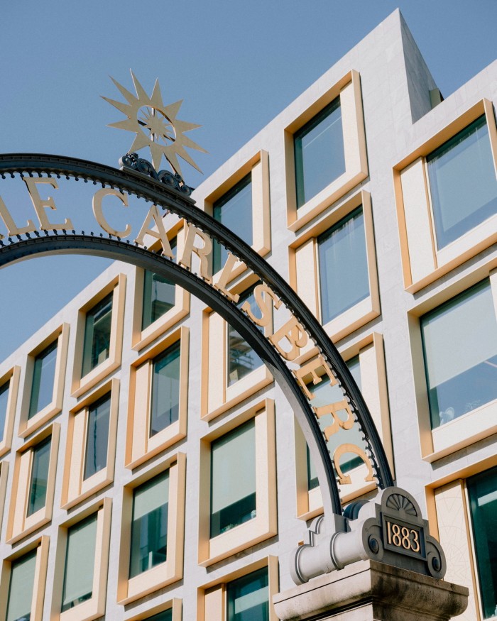 Detail of the arched Star Gate — on top of which is a bronze star — with the facade of a contemporary grey and white building behind it