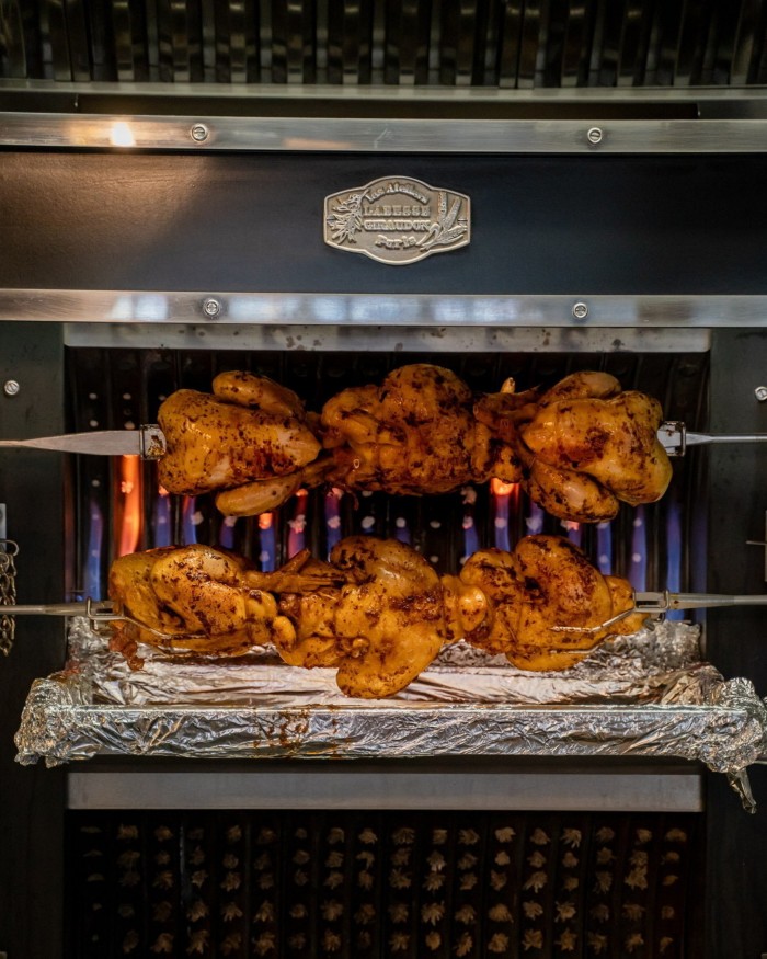 Several chickens on a rotisseries at Pique Nique