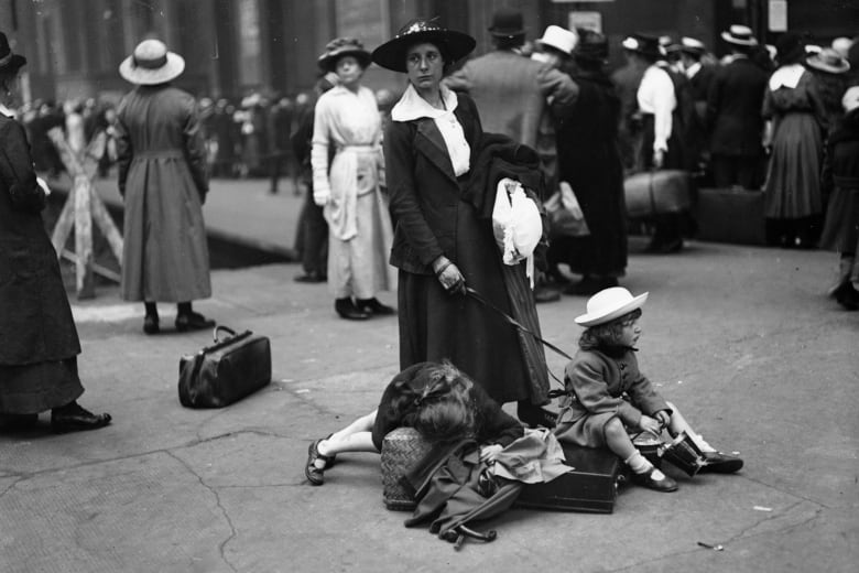 A vintage black and white photo of a woman with two young children