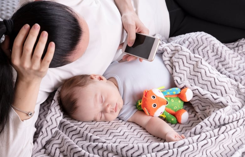 Mom works on the phone when the baby sleeps nearby. 