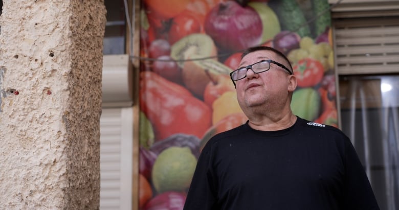 Ginadi Toybis,  a fishing shop owner in north Haifa, looks to the sky after the sirens sounded the all-clear following a Hezbollah missile attack.