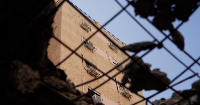 Peering through the hole in an apartment's roof caused by a Hezbollah rocket.