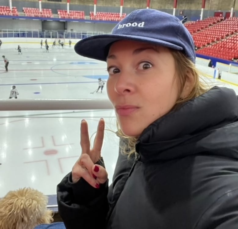 A selfie of a woman sitting in a hockey arena.