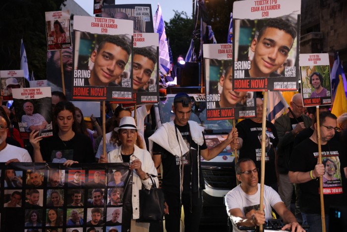 Relatives and supporters of Israeli hostages hold images of their loved ones during a protest