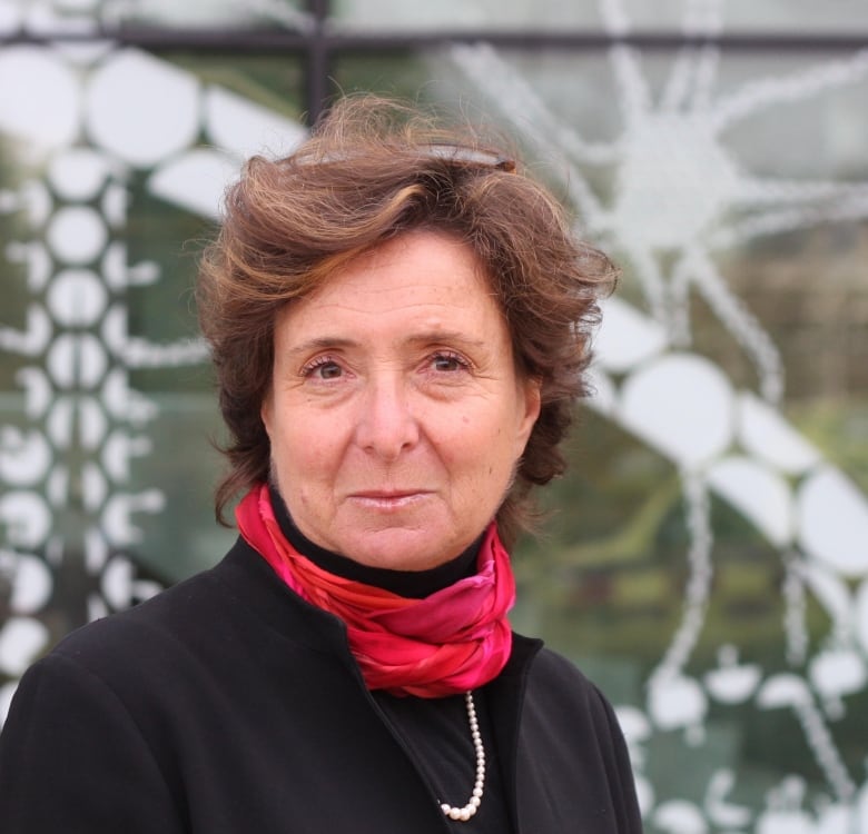 Portrait of a woman with short brown hair and a bright red scarf