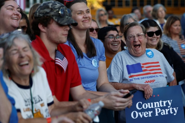 People smile over sign that says "Country Over Party"