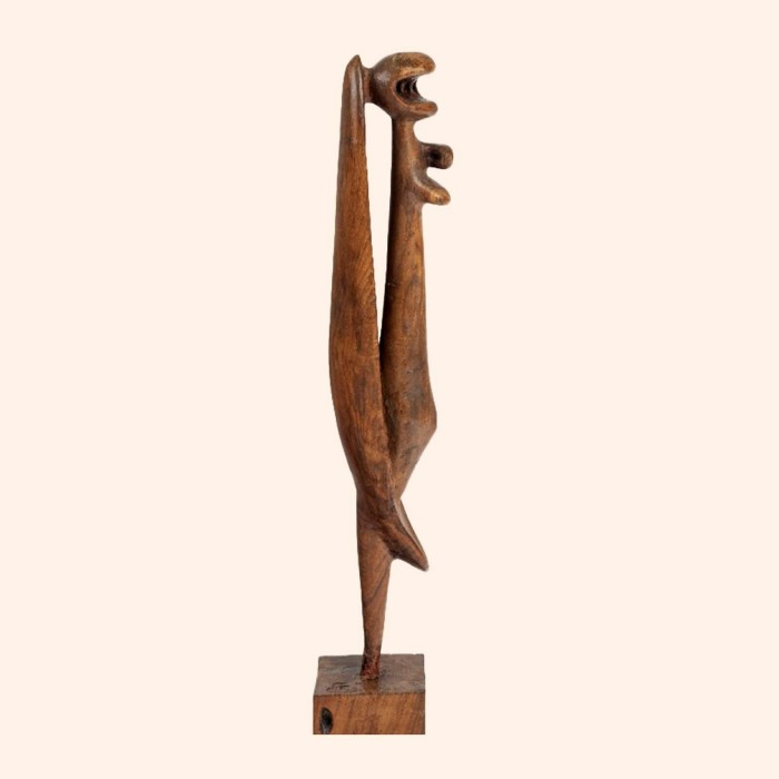 Tall, thin wooden sculpture drawing from African art techniques