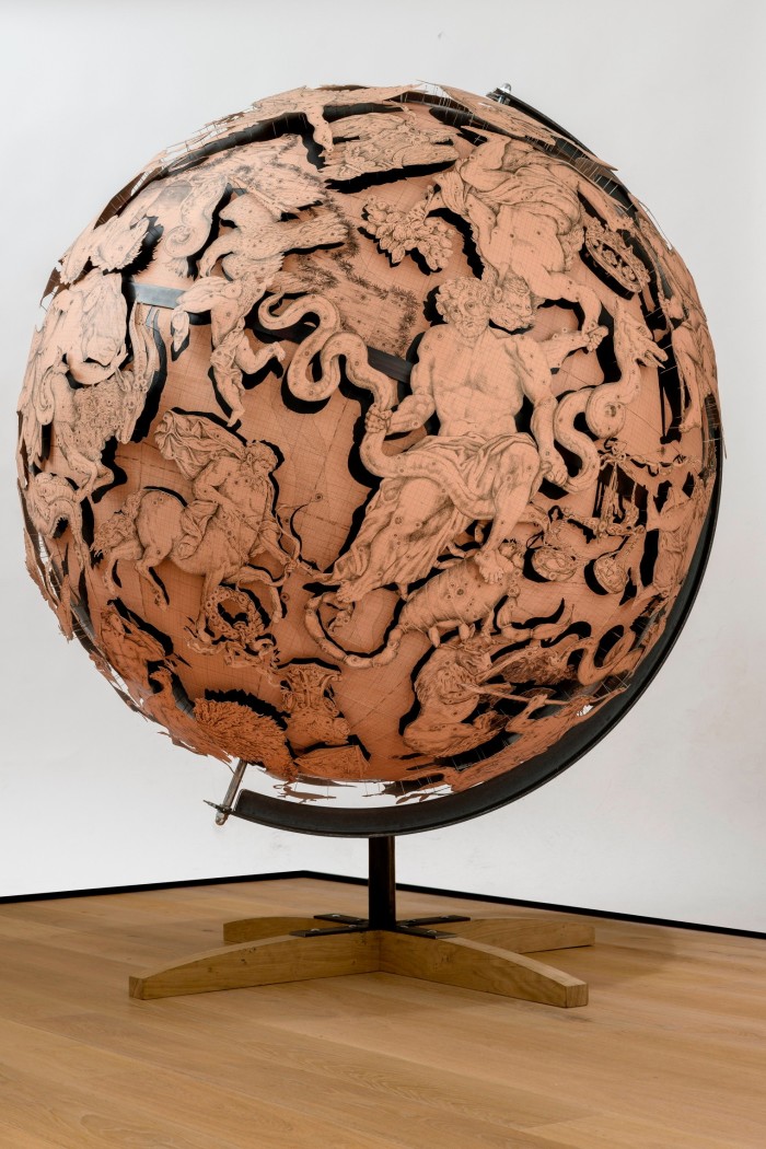 A large globe model of the Earth is wreathed in fantastical beings and creatures