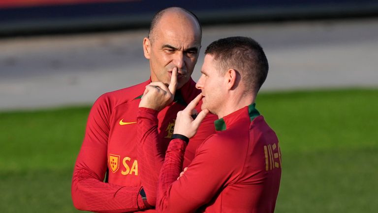 Portugal head coach Roberto Martinez talks with assistant coach Anthony Barry, right, during a Portugal soccer team training session in Oeiras, outside Lisbon, Monday, March 20, 2023. Portugal will play Liechtenstein Thursday in a Euro 2024 qualifying match in Lisbon, the first game under the new team head coach Roberto Martinez. (AP Photo/Armando Franca)