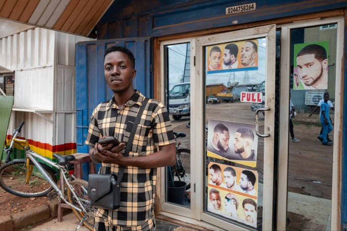 A man stands outside a barber’s shop