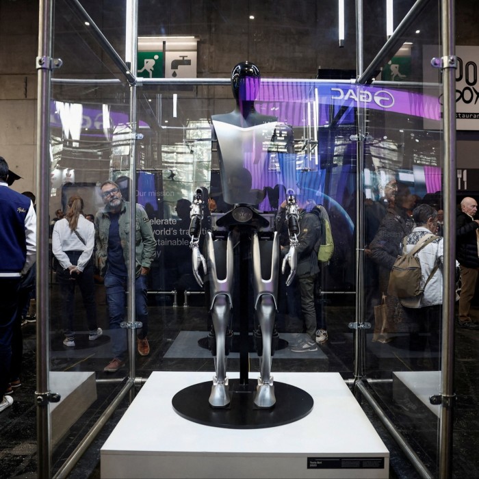 A Tesla Optimus Robot in a glass case