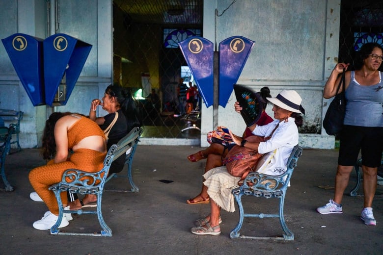 People are seen waiting for the bus in Matanzas, Cuba, amid a nationwide blackout caused by a power-grid failure.