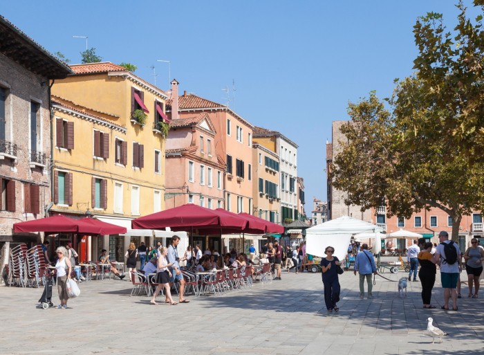 People eating at open-air restaurants on Campo Santa Margherita on a sunny day