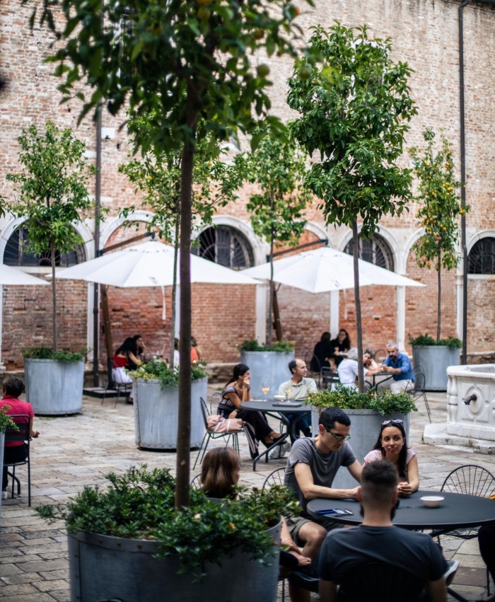 People sitting at tables in the courtyard of Combo Venezia