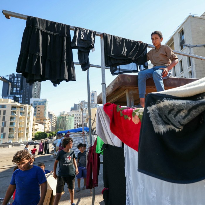 Displaced children are pictured next to makeshift shelters at a parking lot in central Beirut