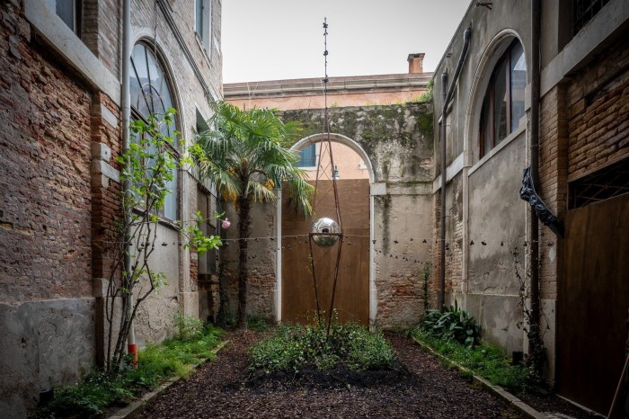 Precious Okoyomon’s ‘Pre–Sky / Emit Light: Yes Like That’ at Nigeria’s pavilion: a metallic structure resembling a radio mast in the middle of an enclosed historic courtyart