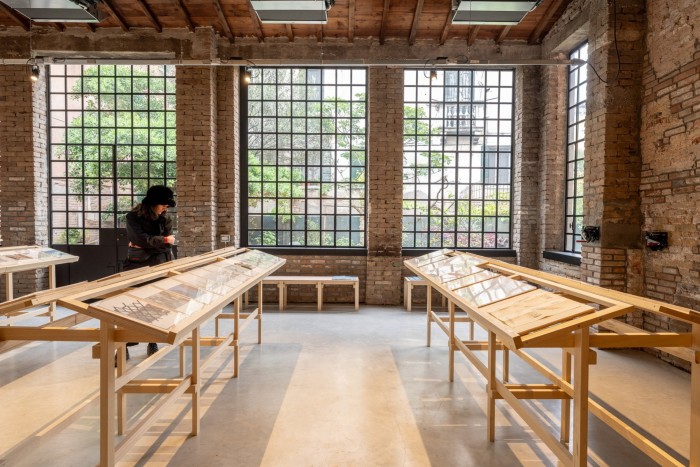 Artworks on desks in rows in front of latticed windows as part of ‘By the Means at Hand’ at the Croatia Pavilion 