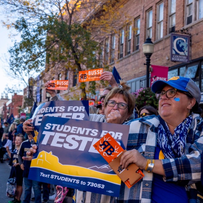 Supporters of Jon Tester hold campaign signs that read ‘Students for Tester’ at the Montana State University Homecoming Parade in Bozeman, Montana.