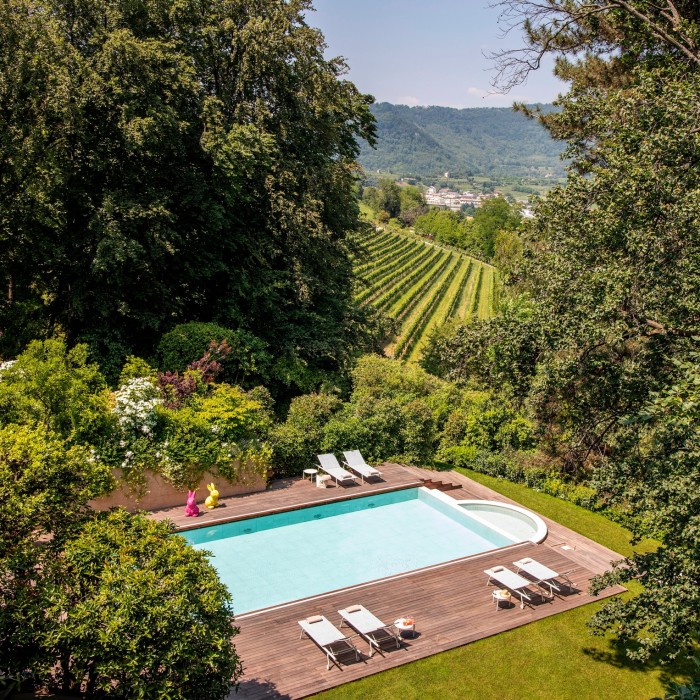 An aerial shot of the hotel’s outdoor pool, surrounded by cypress trees