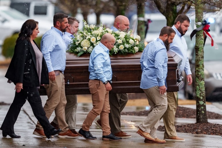 Six men carry a casket