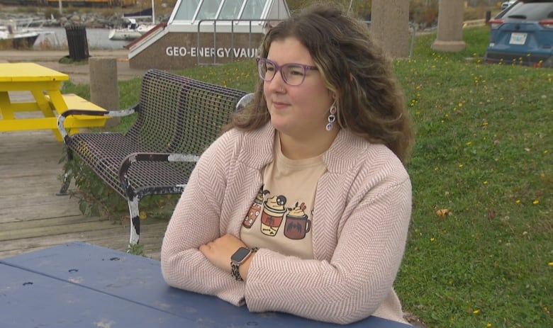 A woman sitting at a picnic bench. 