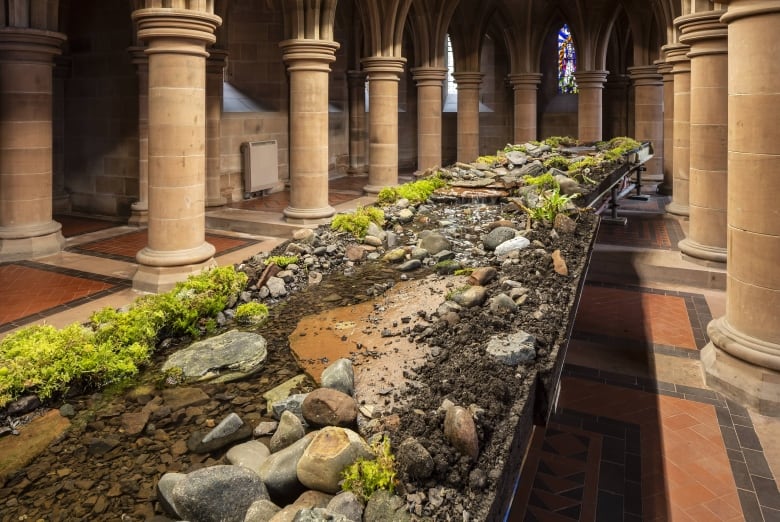 A raised riverbed runs through the interior of a Gothic Revival crypt.