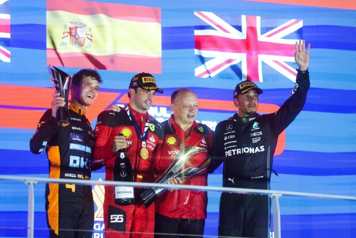 Ferrari driver Carlos Sainz, second left, won the 2023 Singapore F1 Grand Prix with team manager Vasseur beside him. McLaren’s Lando Norris, left, and Mercedes’ Lewis Hamilton, far right, came second and third respectively